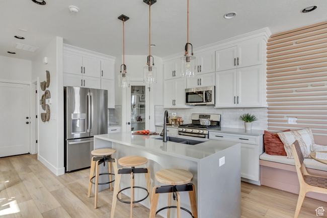 Kitchen featuring stainless steel appliances, light wood finished floors, decorative backsplash, and recessed lighting | Image 27
