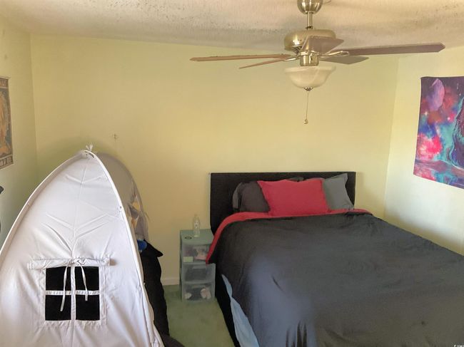 Carpeted bedroom with ceiling fan and a textured ceiling | Image 10