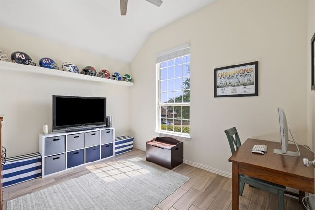Versatile office space with glass double doors, built-in shelving, and a picture window with front yard views. | Image 6