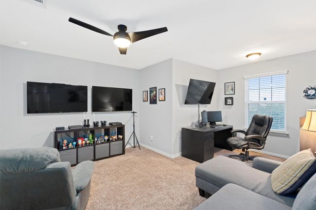 Carpeted living room featuring ceiling fan and baseboards | Image 28