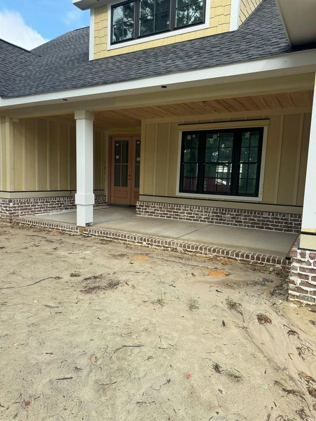 Entrance to property featuring board and batten siding, roof with shingles, and a porch | Image 15