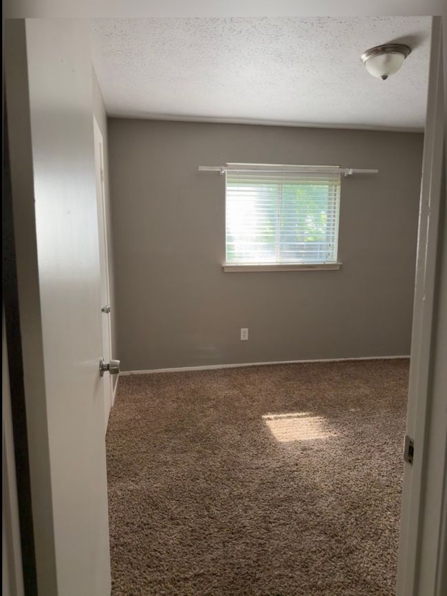 Carpeted spare room featuring a textured ceiling and baseboards | Image 17