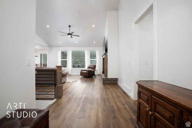 Living room with wood-type flooring, high vaulted ceiling, and ceiling fan | Image 6