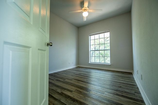 Unfurnished room with dark wood-style floors and ceiling fan | Image 5