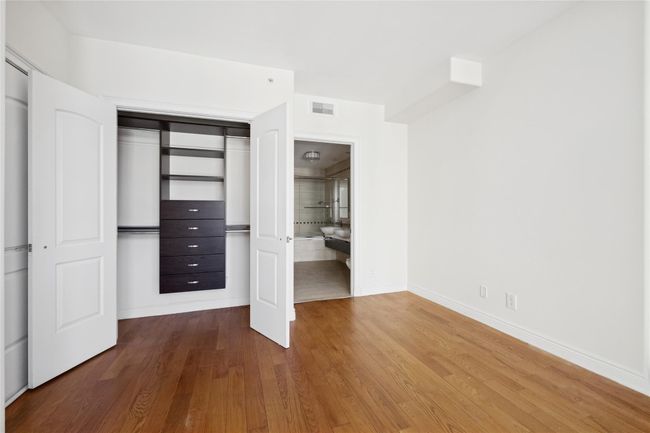 Unfurnished bedroom featuring a closet, visible vents, baseboards, and wood finished floors | Image 8