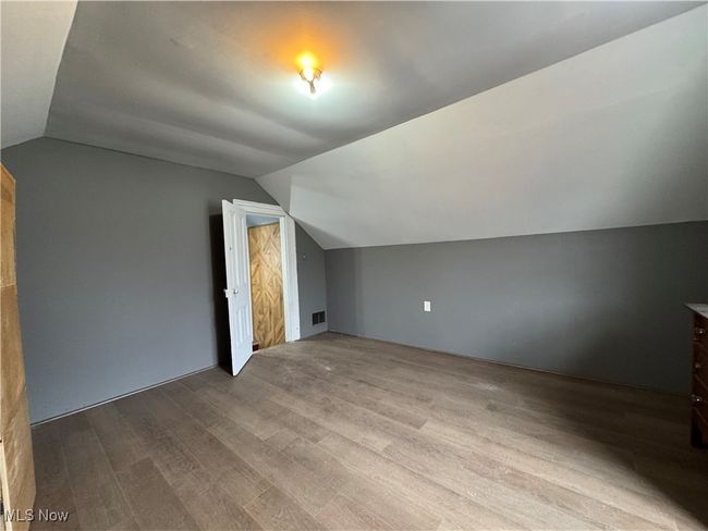 Bonus room featuring lofted ceiling, wood finished floors, and visible vents | Image 24