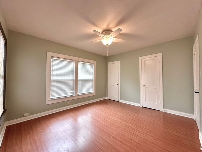 Unfurnished bedroom featuring wood finished floors, multiple closets, and ceiling fan | Image 10
