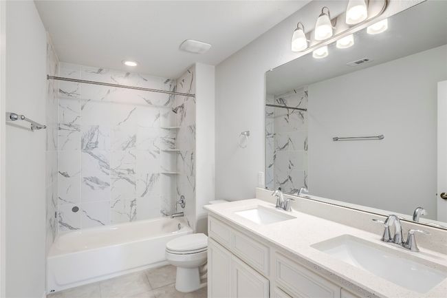 Bathroom featuring double vanity, toilet, shower combination, and tile patterned flooring | Image 27