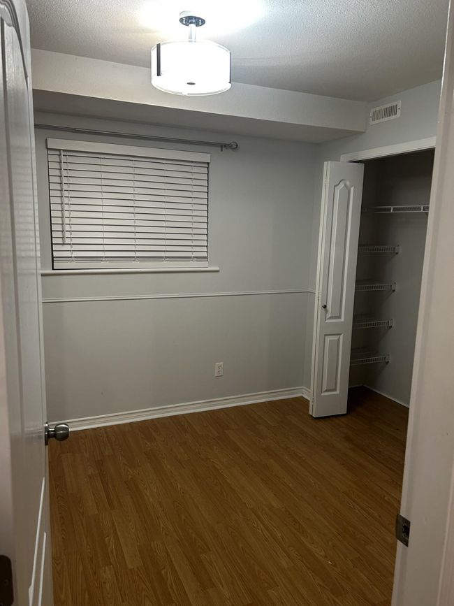 Unfurnished bedroom featuring wood finished floors, a closet, and baseboards | Image 33