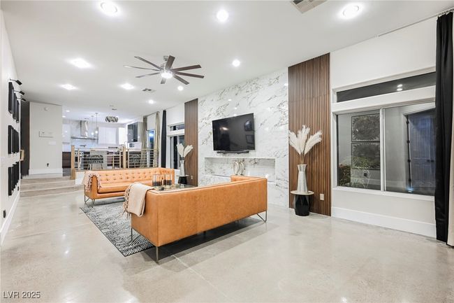 Living area with visible vents, an accent wall, a ceiling fan, recessed lighting, and finished concrete flooring | Image 21