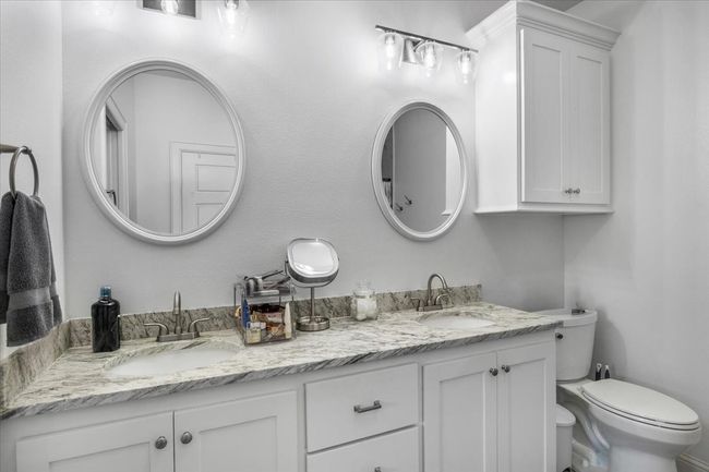 Bathroom featuring toilet, double vanity, and a sink | Image 19