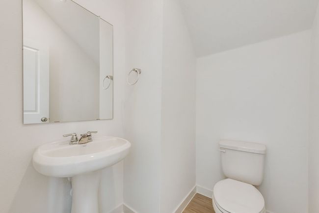 Half bathroom featuring toilet and wood finished floors | Image 17