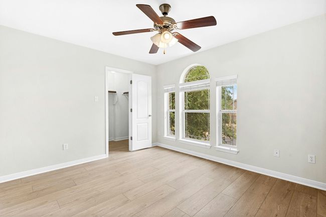 Empty room featuring ceiling fan and light wood-style floors | Image 18