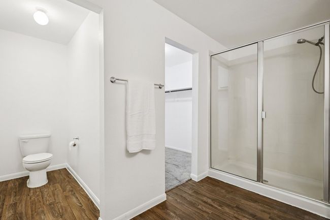 Bathroom featuring a shower stall, wood finished floors, and a spacious closet | Image 22
