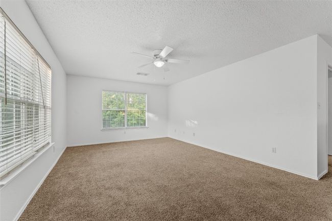 Carpeted spare room with ceiling fan, a textured ceiling, and baseboards | Image 20