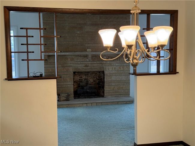 Unfurnished living room featuring carpet flooring and a stone fireplace | Image 12
