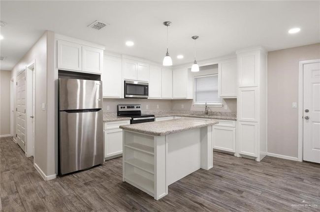 Kitchen with appliances with stainless steel finishes, open shelves, white cabinetry, recessed lighting, and dark wood-style flooring | Image 4