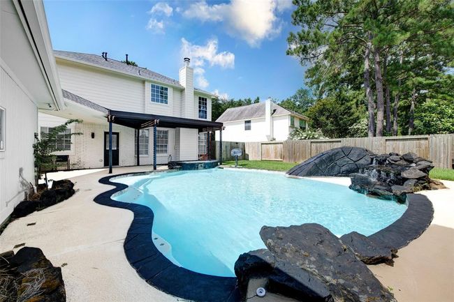 Your huge beautiful pool has a jacuzzi attached, built in water slide and basketball hoop, mood lights, and outdoor shower. | Image 24