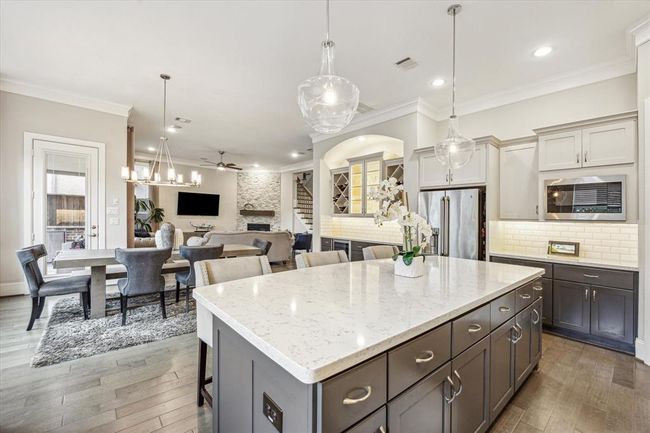 Entertain with ease in the open concept kitchen/living/dining room. The centrally located bar off to the right has ample room to store your wine. | Image 13