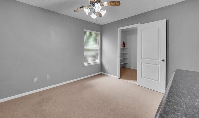 Unfurnished bedroom featuring carpet, a textured ceiling, baseboards, and a ceiling fan | Image 13