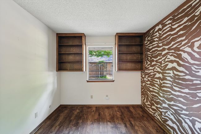 Unfurnished room with baseboards, wood finished floors, and a textured ceiling | Image 10