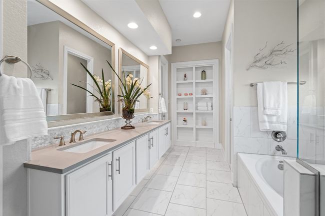 The en-suite bathroom is spa-inspired, boasting dual vanities, a soaking tub, a walk-in shower with elegant tile finishes, and a spacious walk-in closet. | Image 19