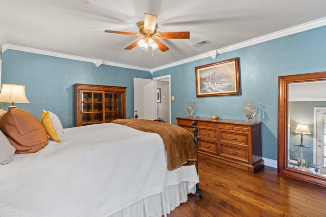 Primary Bedroom with ceiling fan, dark hardwood / wood-style floors, and ornamental molding | Image 26