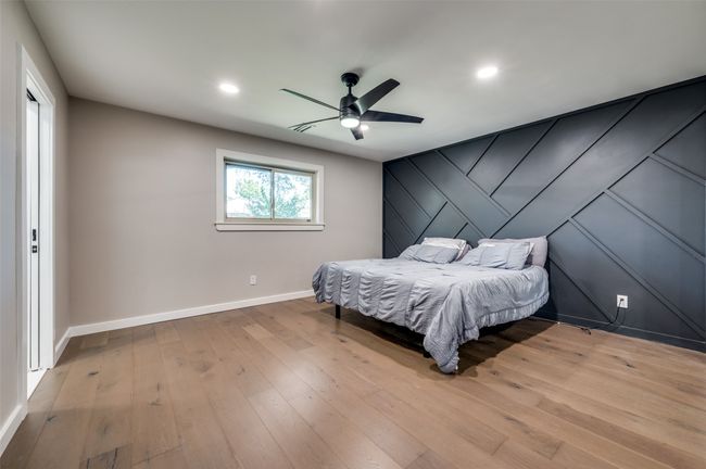 Bedroom with an accent wall, light wood finished floors, recessed lighting, and a ceiling fan | Image 15