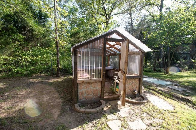 View of greenhouse with ground entrance to storm shelter on the right | Image 14