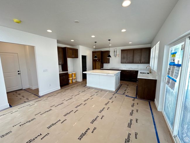 Kitchen featuring dark brown cabinets, healthy amount of natural light, recessed lighting, and a kitchen island | Image 6