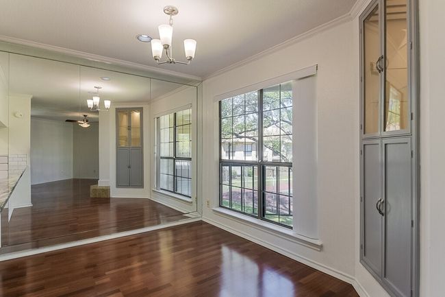 Unfurnished dining area featuring ornamental molding, baseboards, an inviting chandelier, and wood finished floors | Image 10