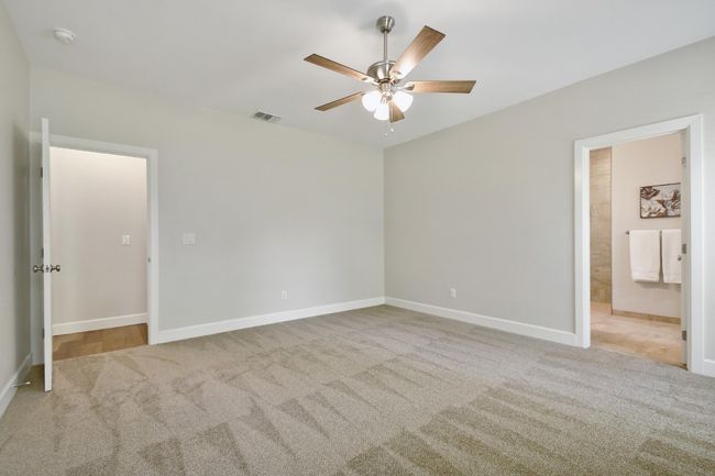 Unfurnished bedroom with carpet floors, a ceiling fan, and ensuite bath | Image 15