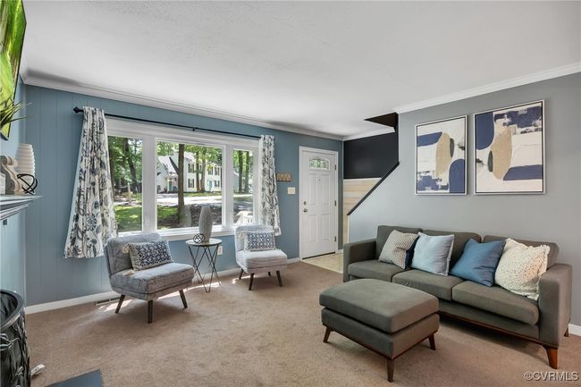 Living area featuring crown molding, carpet, and large windows | Image 8