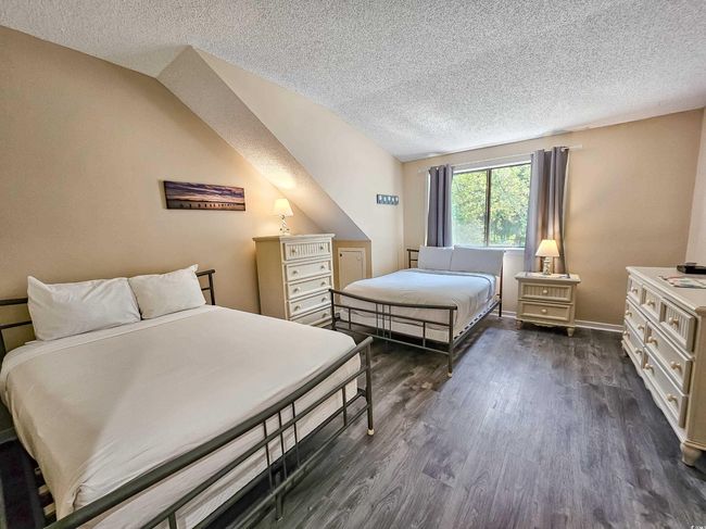 Bedroom with a textured ceiling and dark wood-style floors | Image 27