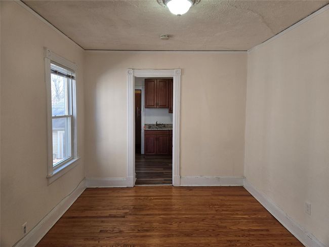 Unfurnished room featuring dark wood-style flooring, baseboards, a textured ceiling, and a sink | Image 8