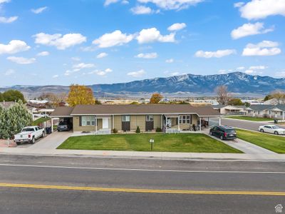 Ranch-style house featuring a carport, a front yard, and a mountain view | Image 1