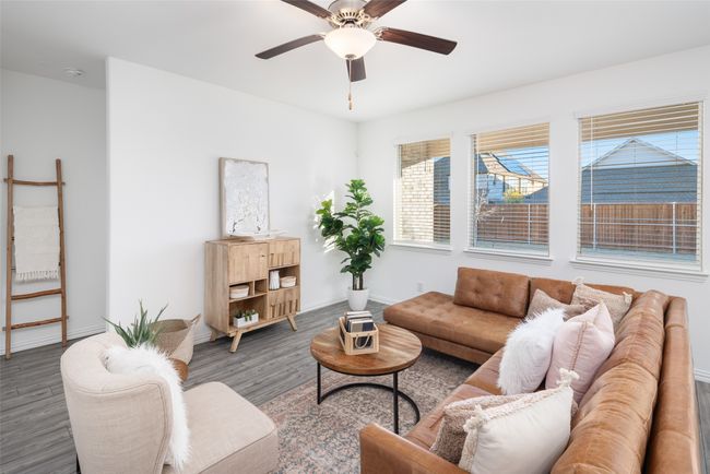 Living area with wood finished floors, a ceiling fan, and baseboards | Image 5