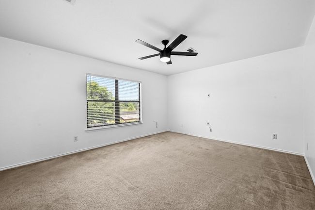 Spare room with a ceiling fan, carpet, and baseboards | Image 21