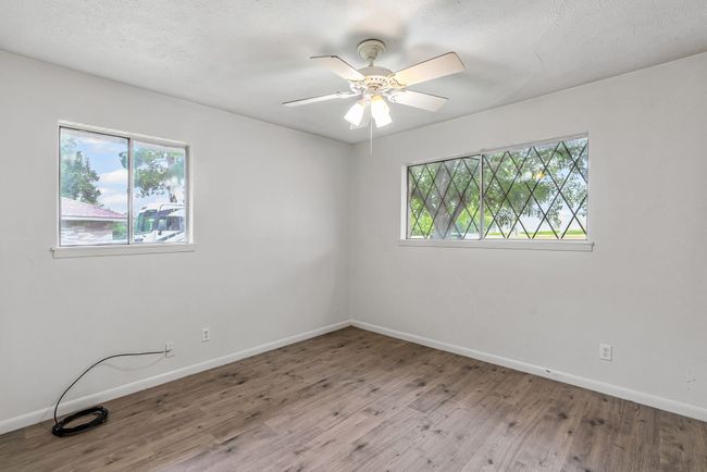 Unfurnished room with wood finished floors and a ceiling fan | Image 9