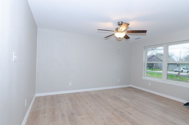 Empty room with visible vents, light wood-style flooring, a ceiling fan, and baseboards | Image 15