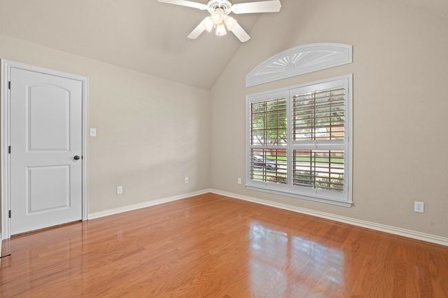 Spare room with a ceiling fan, lofted ceiling, and wood finished floors | Image 24