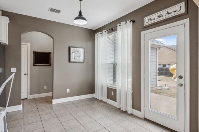 Unfurnished dining area with a healthy amount of sunlight, visible vents, arched walkways, and baseboards | Image 12