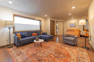 Living room with wood-type flooring and a textured ceiling | Image 2