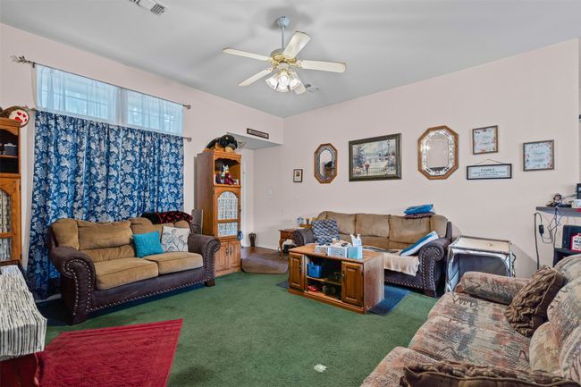Carpeted living room with a ceiling fan | Image 9