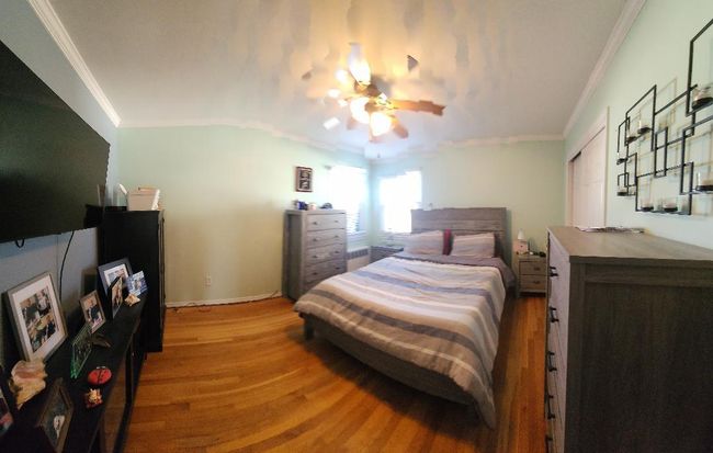 Bedroom featuring baseboards, ornamental molding, wood finished floors, and a ceiling fan | Image 5