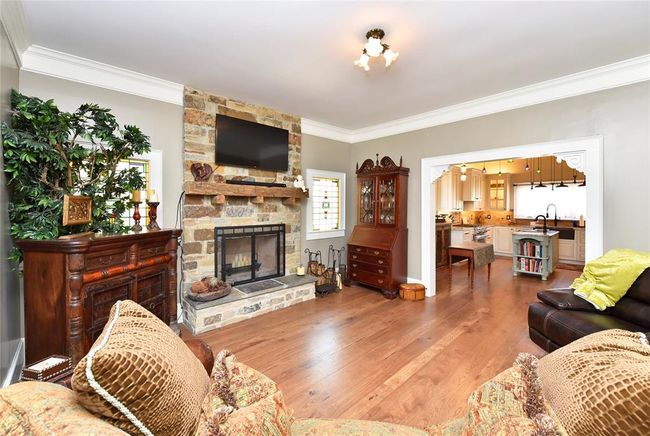 The living room in the Guest house also has a fireplace and is open to the kitchen/dining. | Image 34