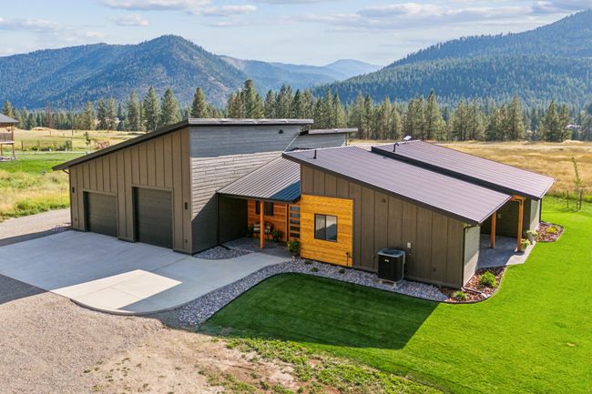 View of front of house featuring a mountain view, central AC, a front yard, and metal roof | Image 7