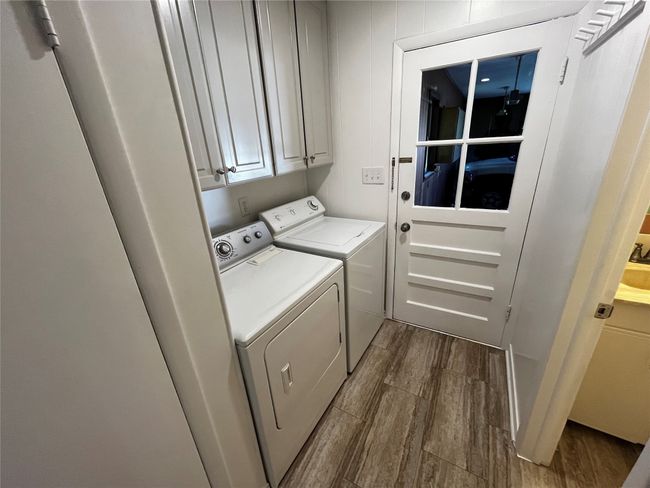 Just inside from the garage entry, and before the kitchen, this utility area features included washer & dryer. | Image 22