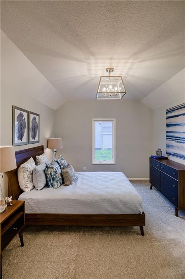 Carpeted bedroom with an inviting chandelier, a textured ceiling, and vaulted ceiling | Image 41