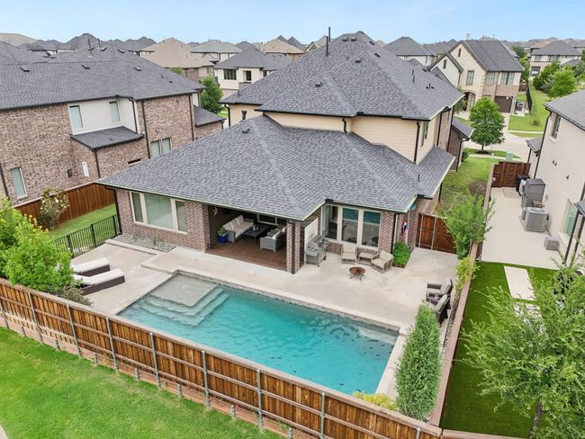 Rear view of house with outdoor lounge area, brick siding, roof with shingles, and a residential view | Image 38